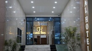 Der Eingang eines Hotels mit Glasfassade, einer Rezeption und einer Treppe zum Empfangsbereich.