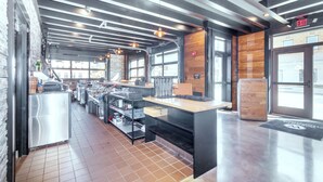 A modern kitchen with stainless steel appliances, wooden accents, and a tiled floor. - Cobblestone Hotel and Suites Janesville (Janesville)