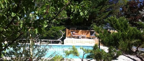 Alberca al aire libre y camastros