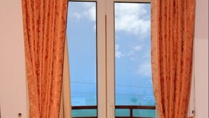 Een kamer met een deur die uitkomt op een balkon.