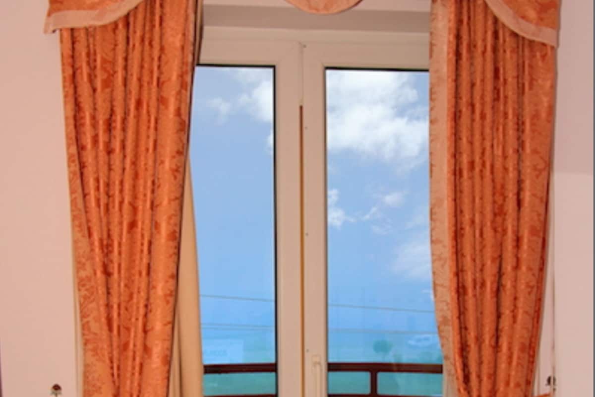 Een kamer met een deur die uitkomt op een balkon.