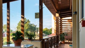 A covered outdoor area with wooden beams, potted plants, and a tiled floor. - Giovanni Mare (Ilida)