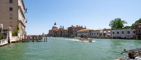 A canal with boats, historic buildings, and a prominent dome structure.