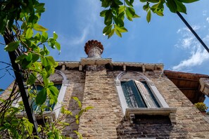 Un edificio storico con facciata in pietra, finestre ad arco e un camino.