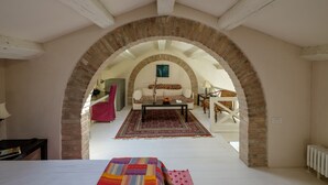 A room with a bed, a sofa, a coffee table, and a patterned rug. - Attico Terrazza (Venice)