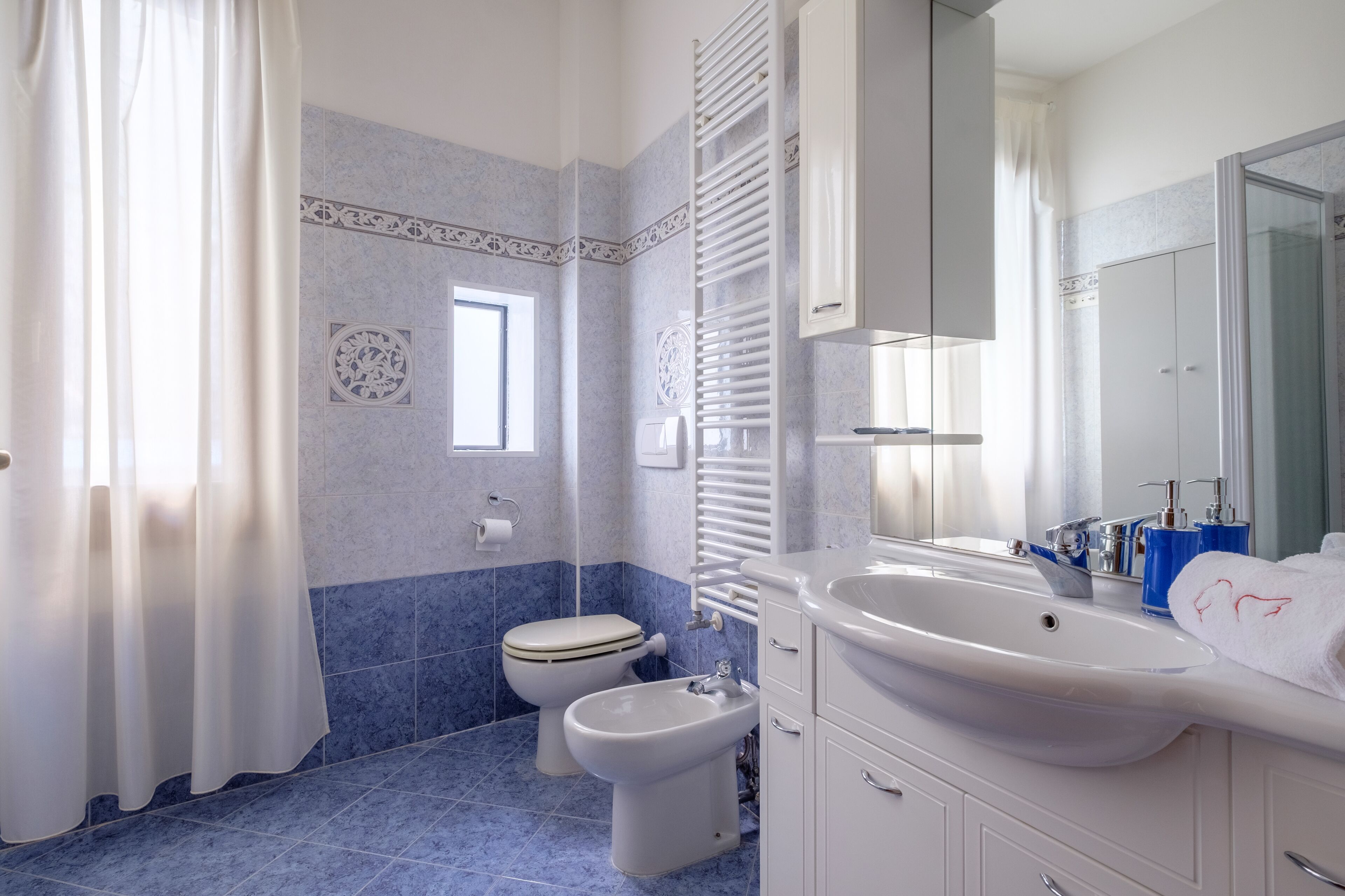 Un baño con inodoro, bidé y lavamanos.