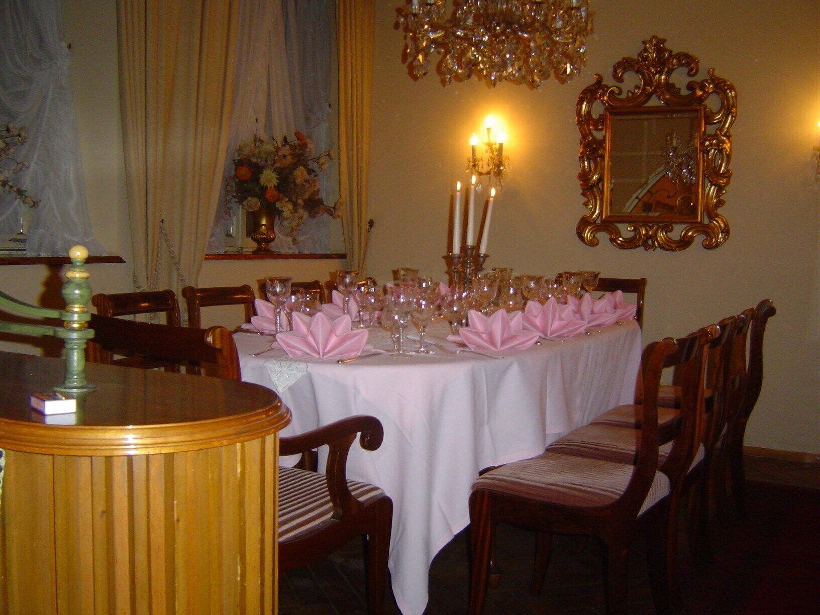 Ein eleganter Speisesaal mit gedecktem Tisch und Holzstühlen.