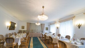 A dining room with multiple tables set for service, a central chandelier, and a long decorative carpet. - Alte Post (Wangen im Allgäu)