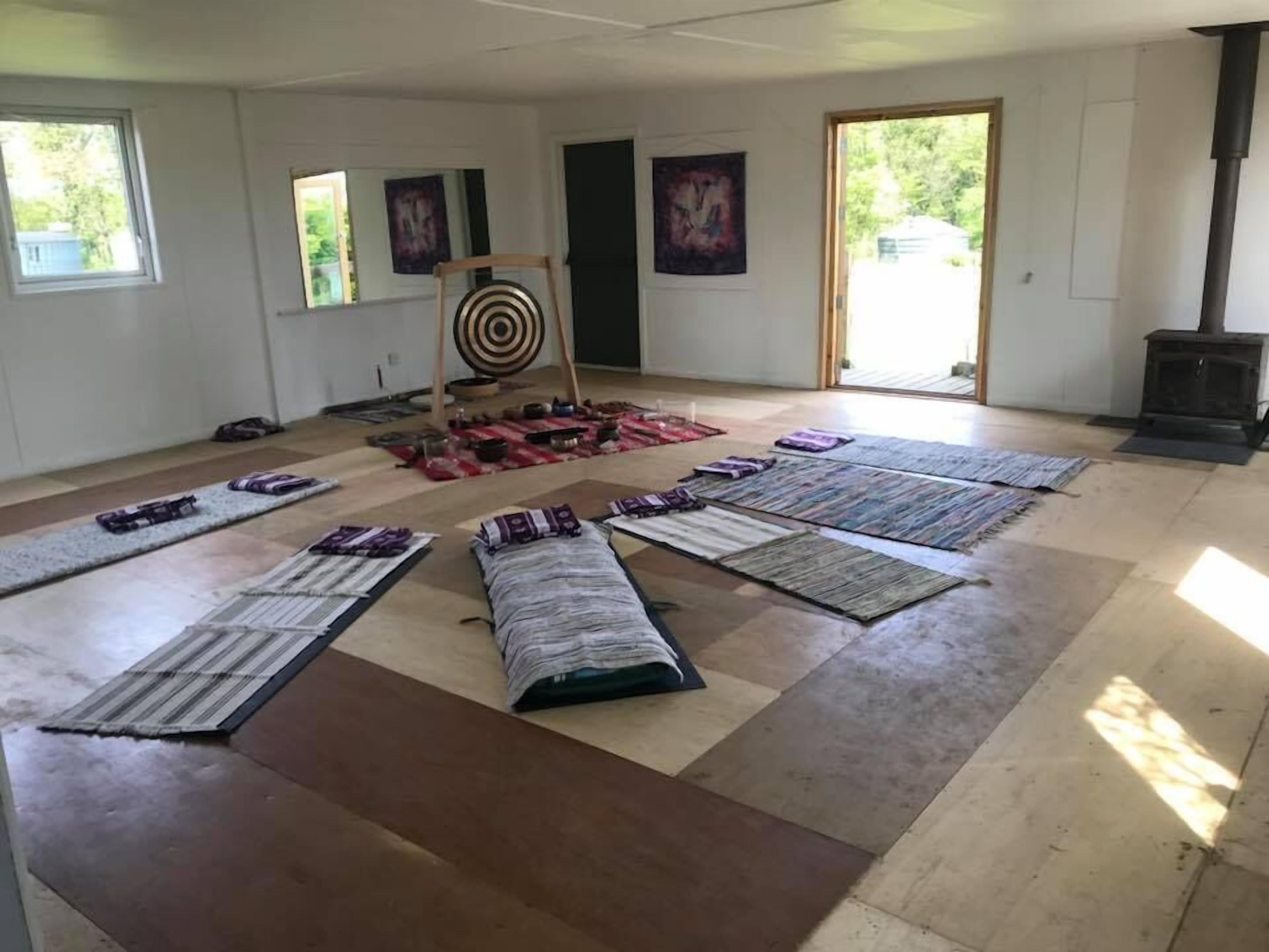 A spacious room with a large open floor area, a target board, and several mats laid out.