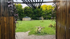 A wooden pergola structure with a gravel pathway leading to a grassy area. - Baby Moon (Guisborough)