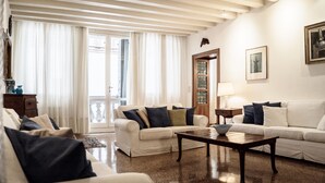 Una sala de estar con un sofá blanco, una mesa de centro y una puerta de madera.