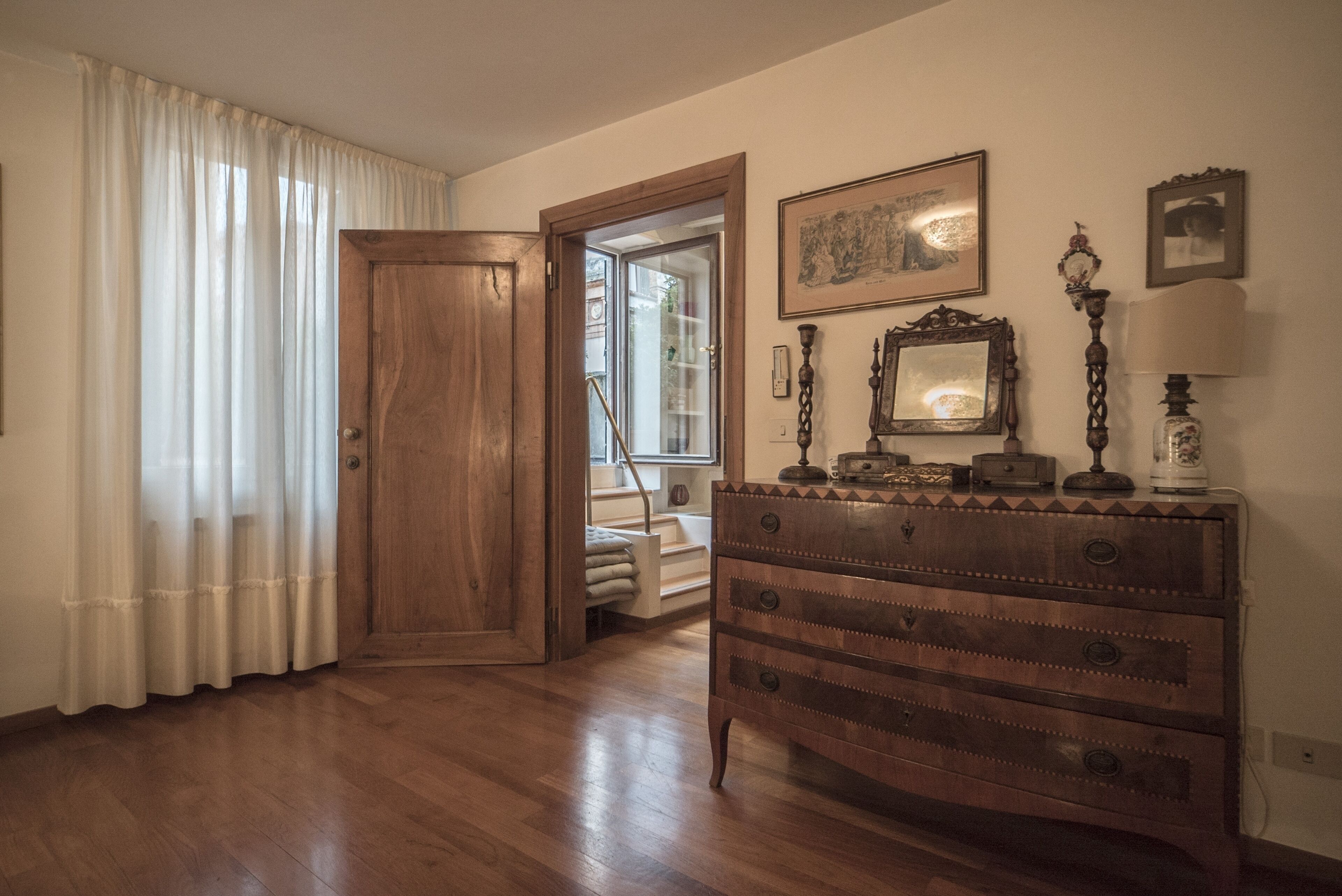Ein Holzkoffer mit Schubladen, ein Spiegel und dekorative Gegenstände an einer Wand.