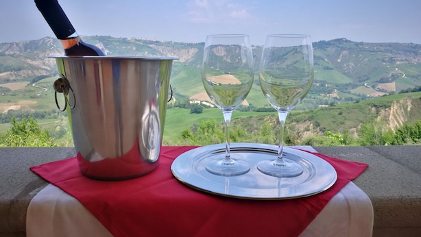 A table with a metal bucket and two wine glasses on a red cloth, overlooking a scenic valley. - Villa Agreste (Cupello)