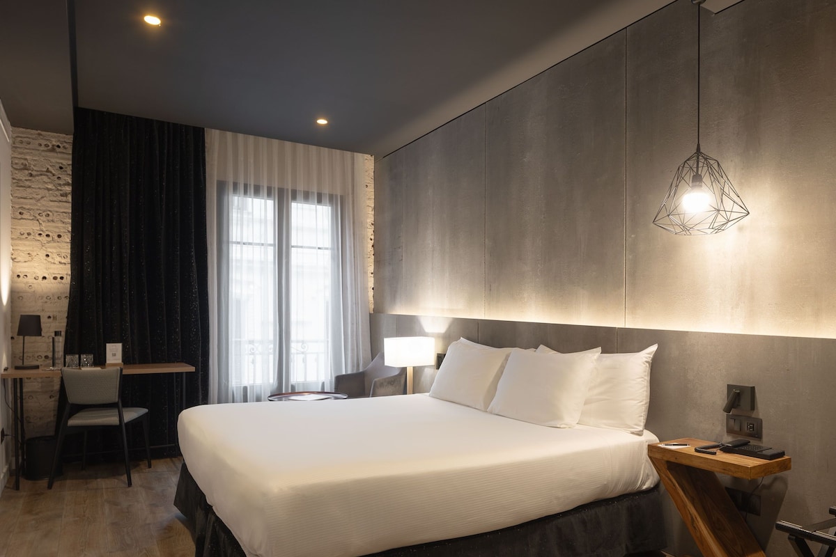 Une chambre à coucher moderne avec un grand lit, un bureau et une chaise.