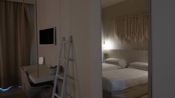 A bedroom with a bed, a desk, a chair, a TV, and a ladder.