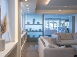 Una sala de estar moderna con un sofá, una mesa de centro y una estantería.