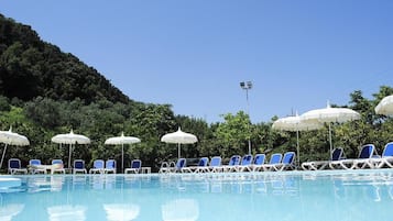 Una piscina al aire libre de temporada, sombrillas