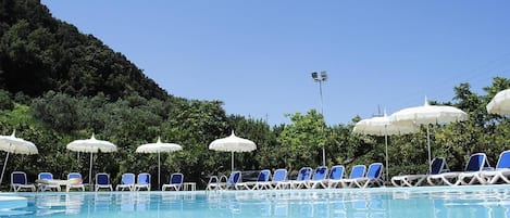 Een seizoensgebonden buitenzwembad, parasols voor strand/zwembad