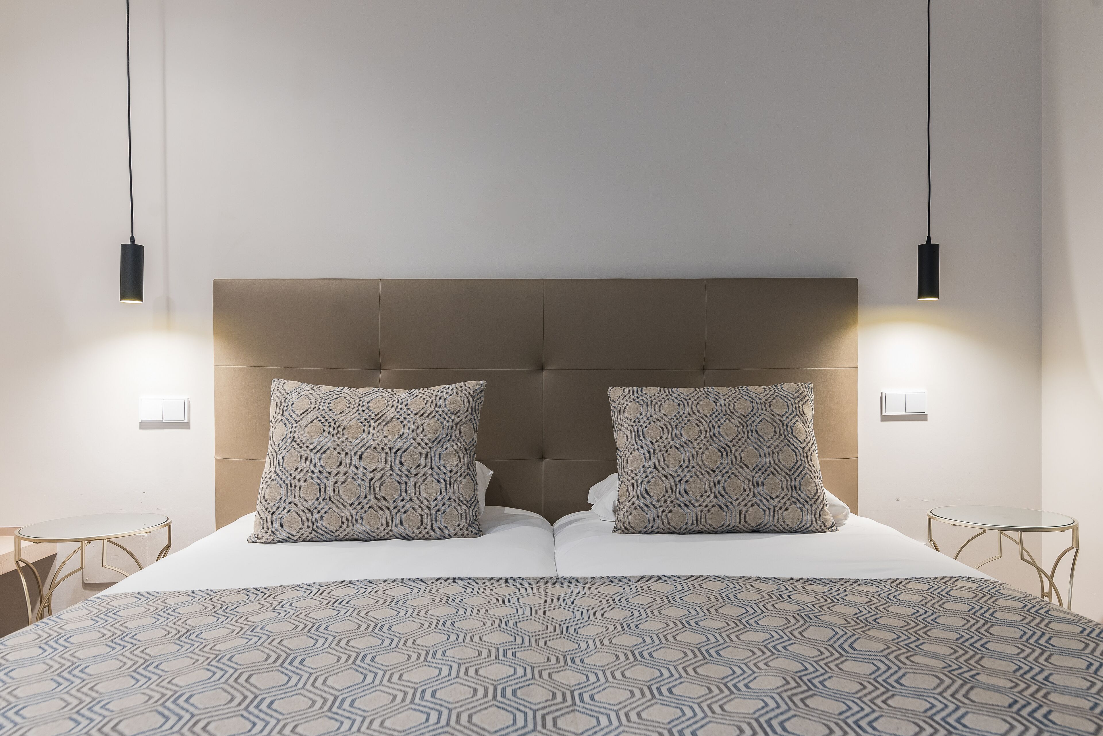 A neatly made bed with patterned bedding, two matching pillows, and a headboard.