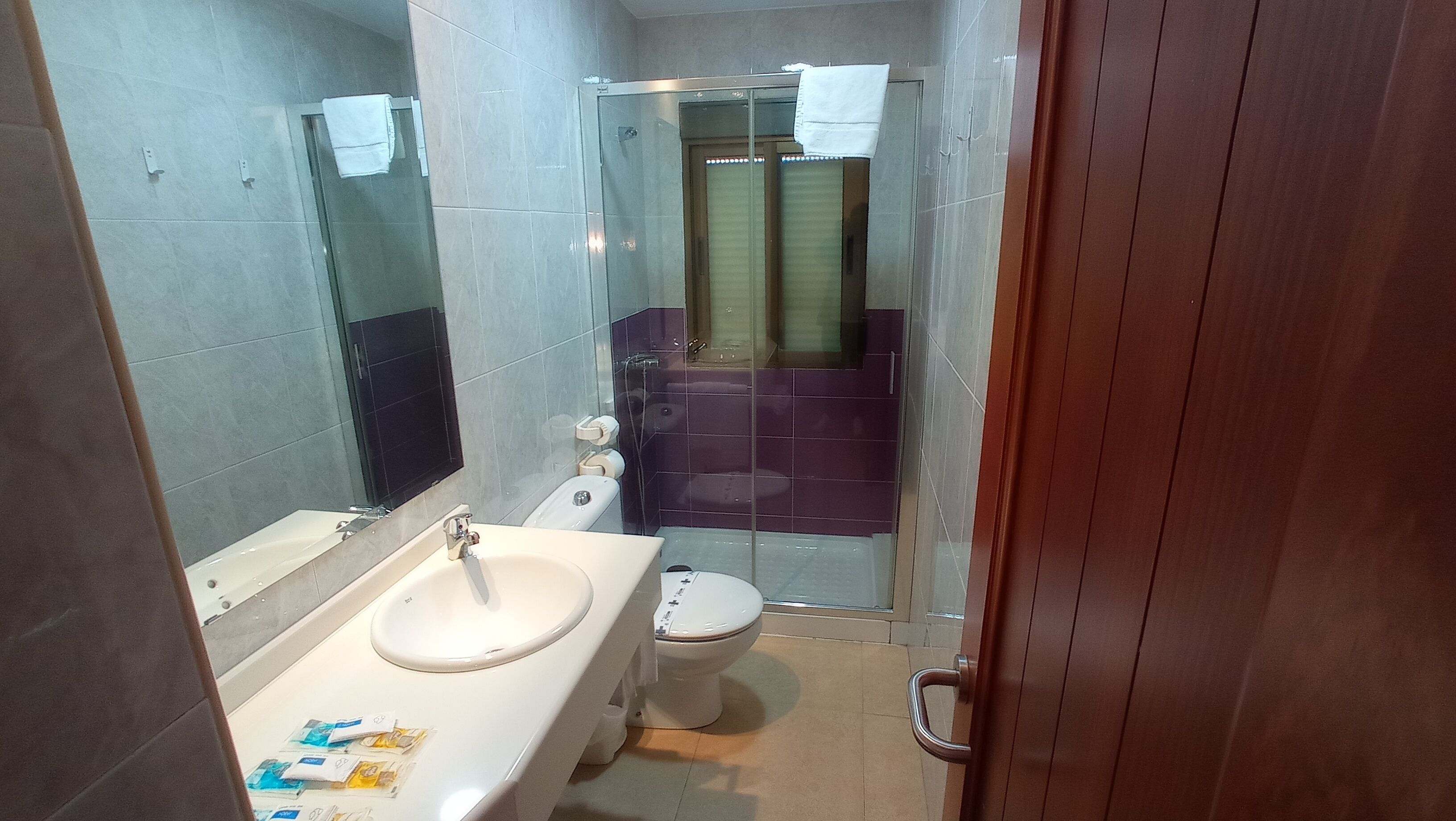 A bathroom with a sink, toilet, and shower.