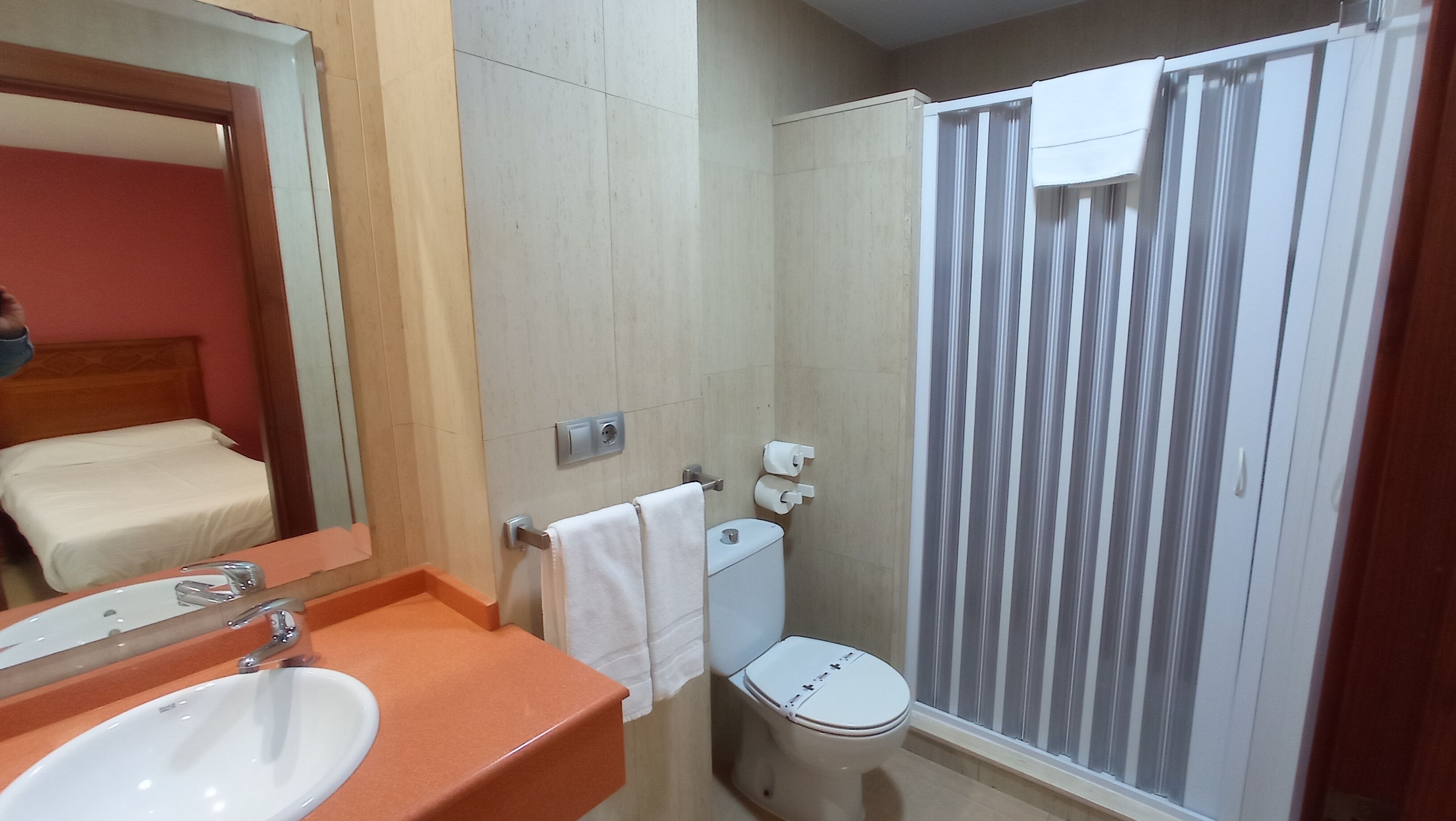 A bathroom with a sink, toilet, and shower curtain.