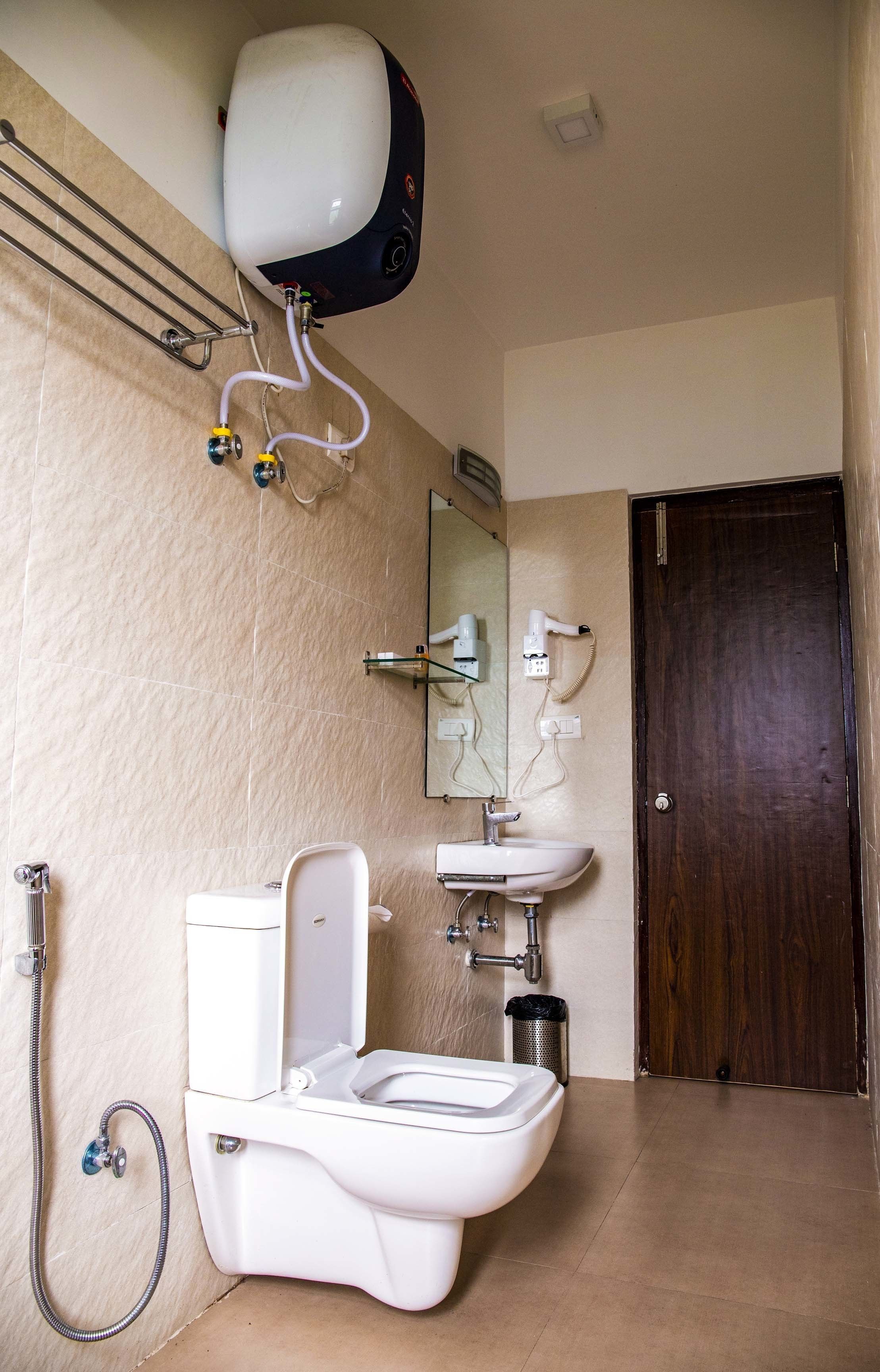 A bathroom with a toilet, sink, and shower.