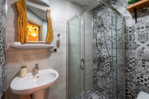 A bathroom with a sink, mirror, and shower. - Mavi Ege Pansiyon (Seferihisar)