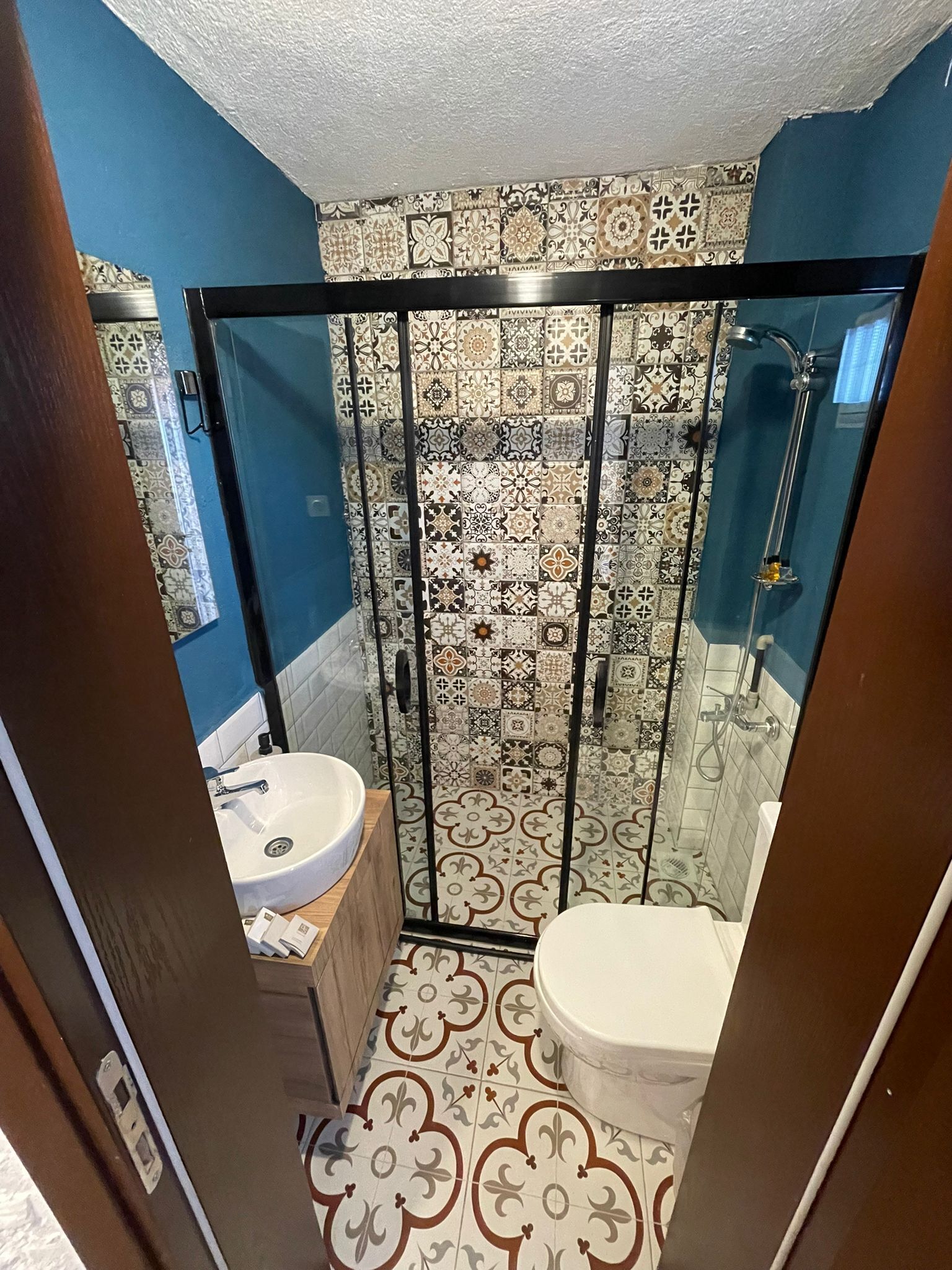 A bathroom with a shower, toilet, and sink.