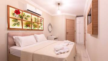 Una habitación de hotel con cama, mesita de noche, espejo, armario y aire acondicionado instalado en la pared.
