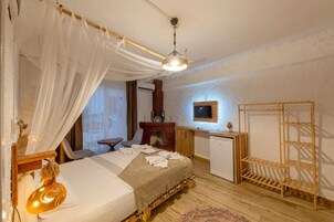 Un dormitorio acogedor con cama, mesita de noche y un pequeño escritorio con televisor.