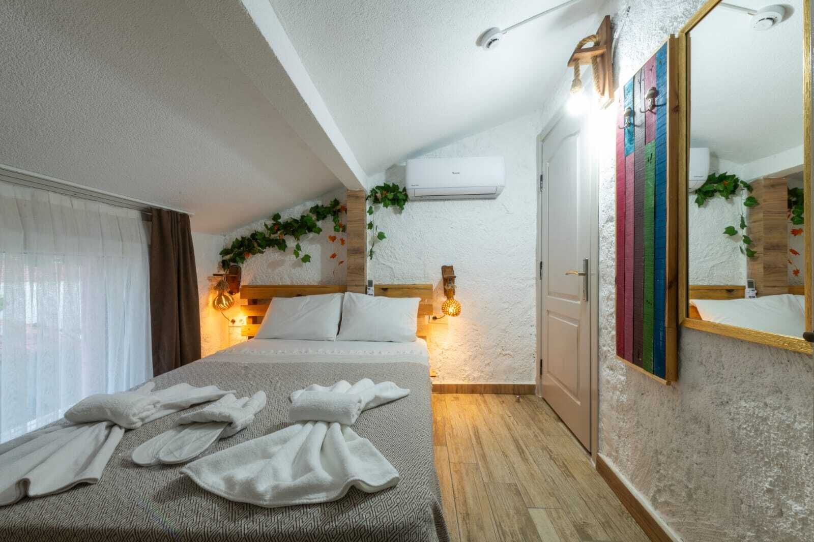 Un dormitorio con una cama, una mesita de noche, un espejo y un equipo de aire acondicionado.