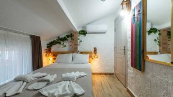 Un dormitorio con una cama, una mesita de noche, un espejo y un equipo de aire acondicionado.