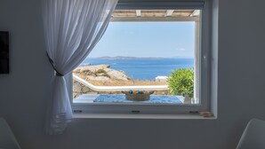 A room with a view of the sea through a window with white curtains. - Sugar Blue (Mykonos)