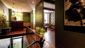 Un interior moderno con una escalera, un mostrador de recepción y vistas al exterior.