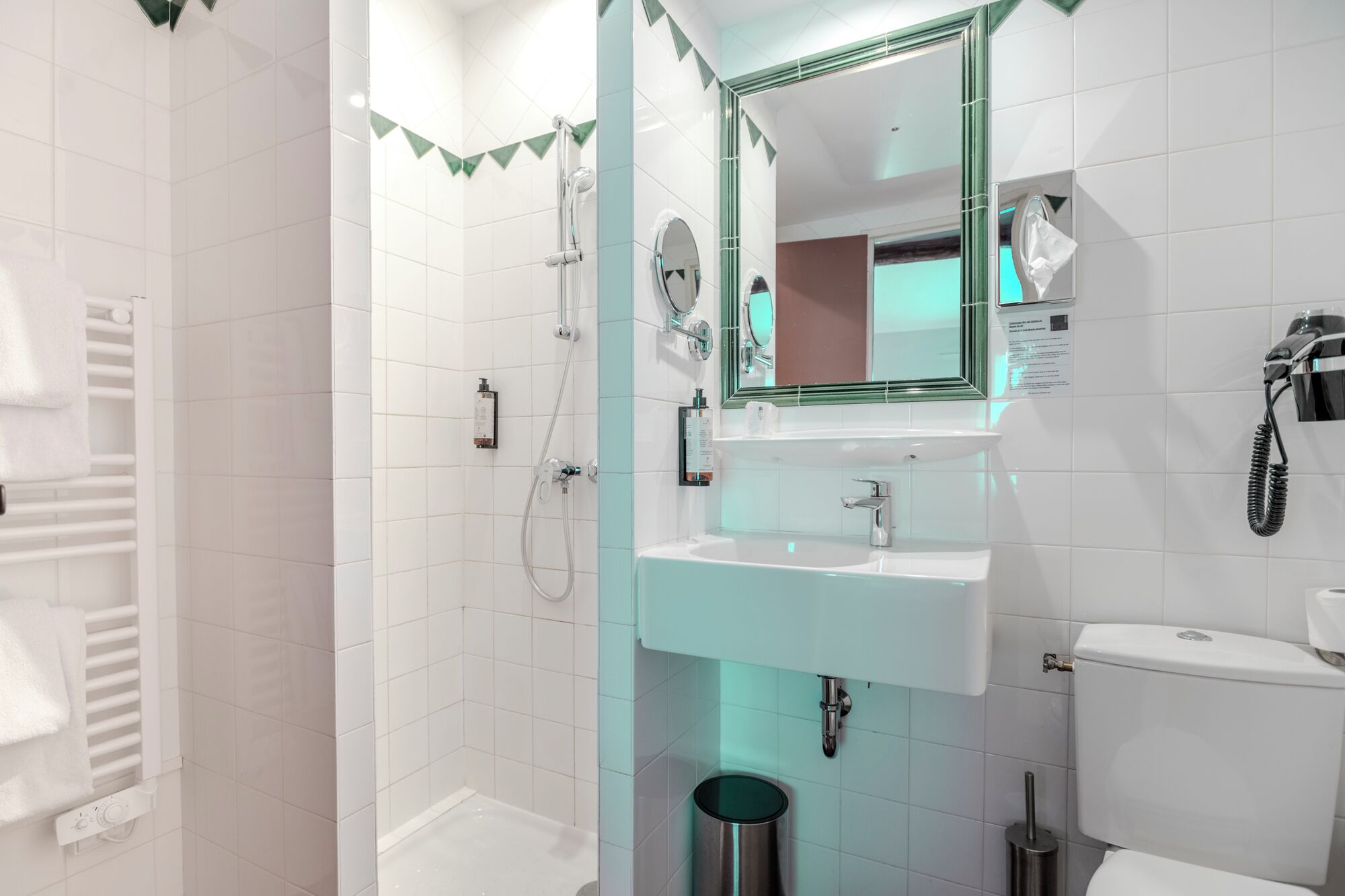 Un bagno moderno dotato di doccia, lavabo, servizi igienici e specchio.