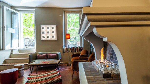 Una sala de estar acogedora con chimenea, un sofá, una mesa de centro y una estantería.