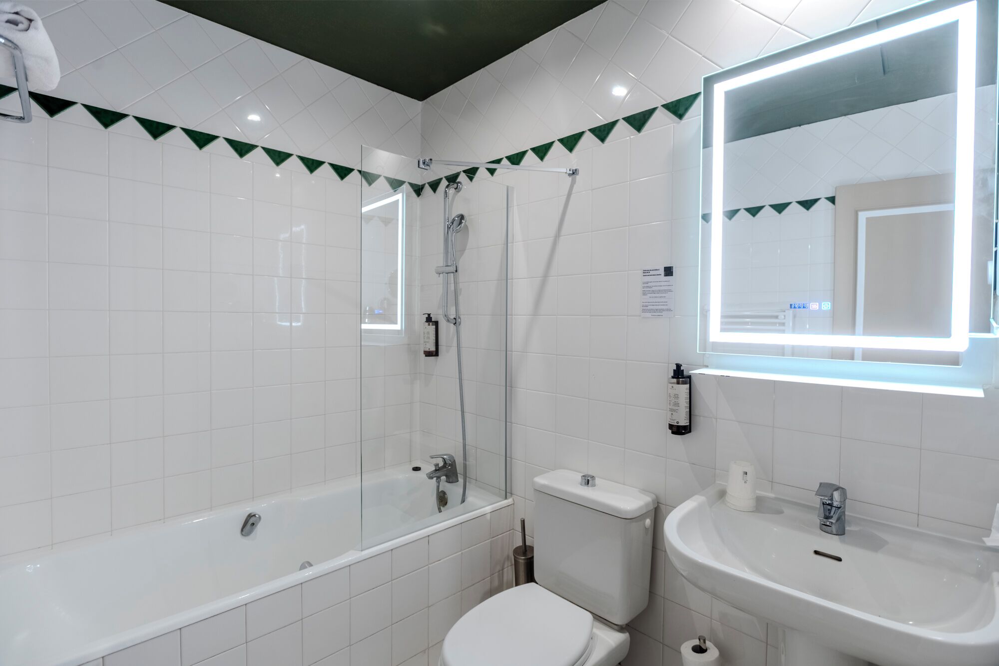 A modern bathroom with a bathtub, toilet, and sink.
