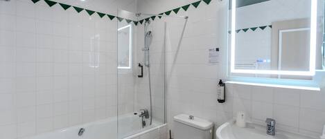 A modern bathroom with a bathtub, toilet, and sink.