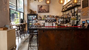 A bar area with a counter, stools, and a variety of bottles and glasses. - Assemblage Boutique (Tel Aviv)