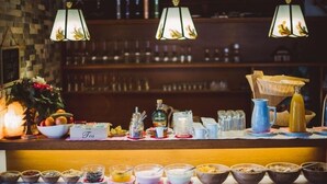 A breakfast bar with a variety of food and drink options, including bowls of cereal, fruits, and a tea station. - Alpenhaus Monte (Neustift Im Stubaital)