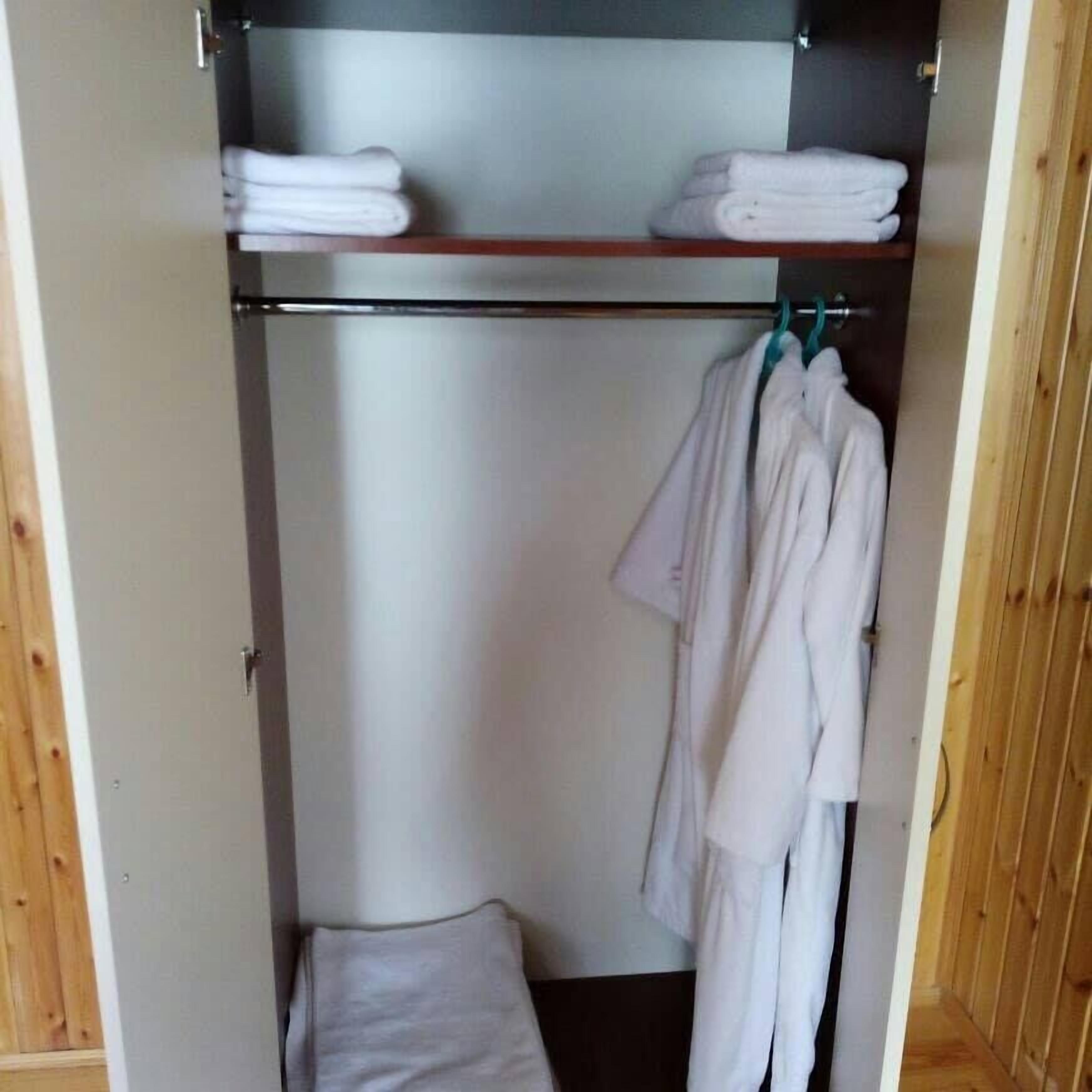 Un vestidor con barra para colgar ropa y estantes para ropa doblada.
