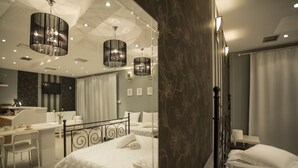 A modern hotel room with a large bed, a desk, and a television. - Olympus (Corinth)
