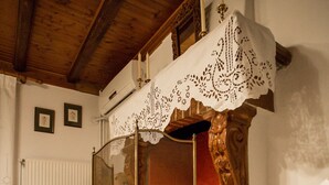 A stone fireplace with a glass screen and candles, set in a room with wooden beams and a white radiator. - Olympus (Corinth)