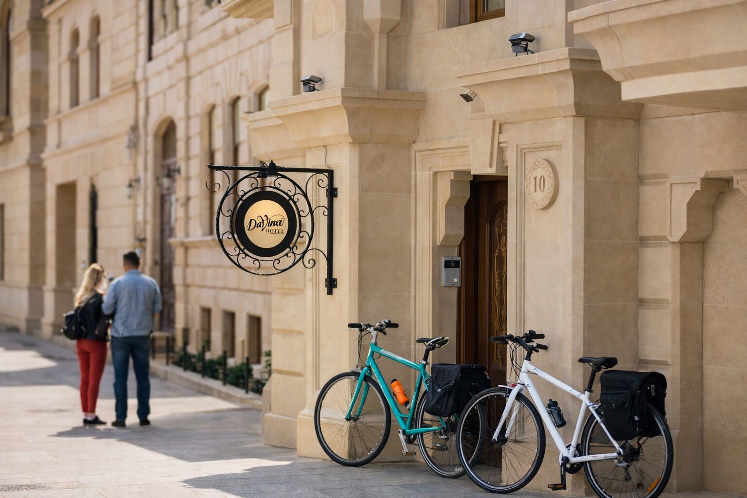 A hotel entrance with a sign reading "DayVina Hotel" and two bicycles parked outside.
