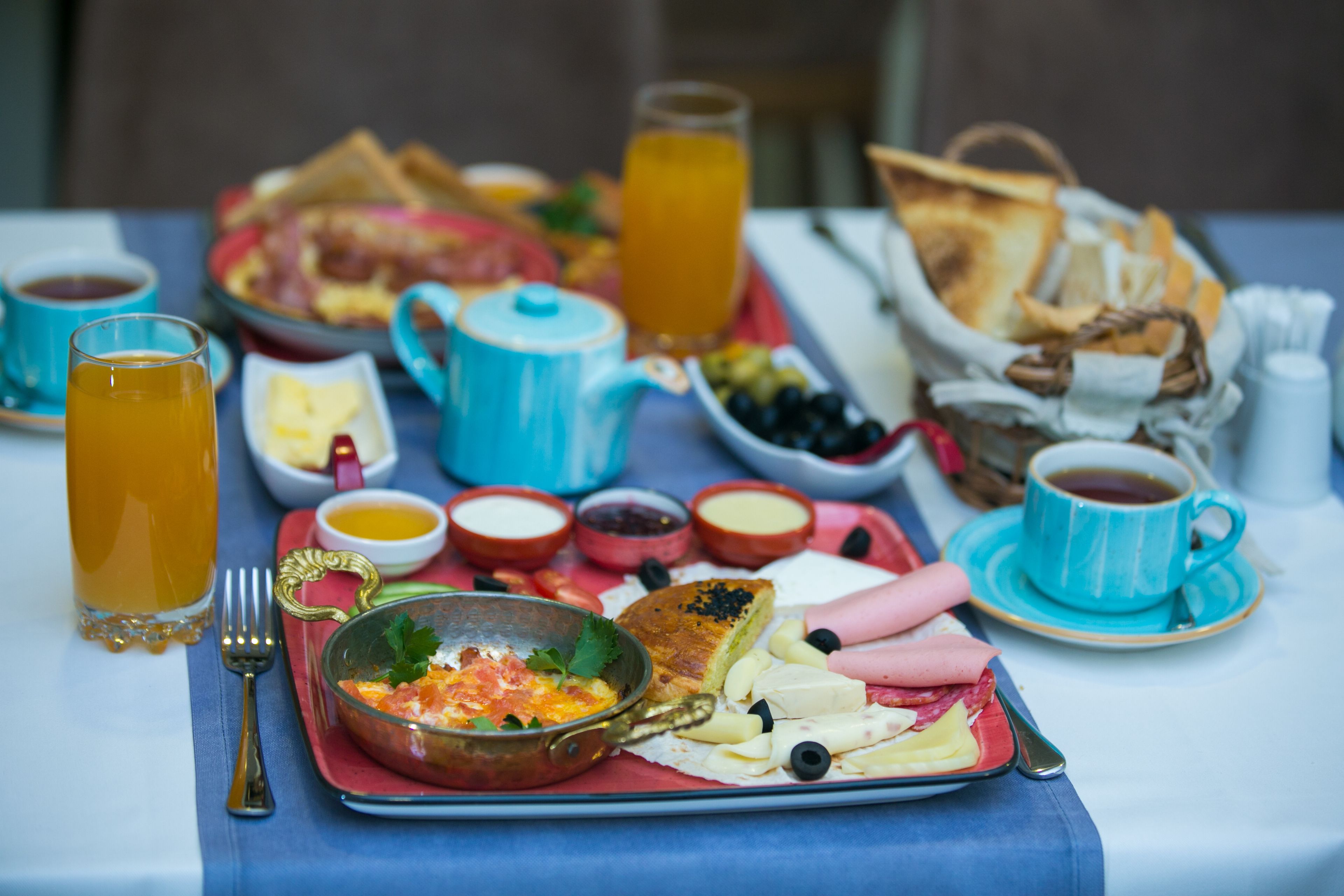 A breakfast table with a variety of food items, including toast, eggs, and fruit.