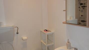 Ein Badezimmer mit Toilette, Bidet, Waschbecken und Spiegel.