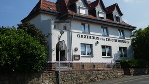 Een gebouw met een bord waarop 'GASTHAUS ZUR OBERENBURG' staat.