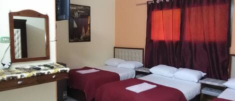 Habitación de hotel con dos camas, un espejo, un cuadro y una cortina roja.