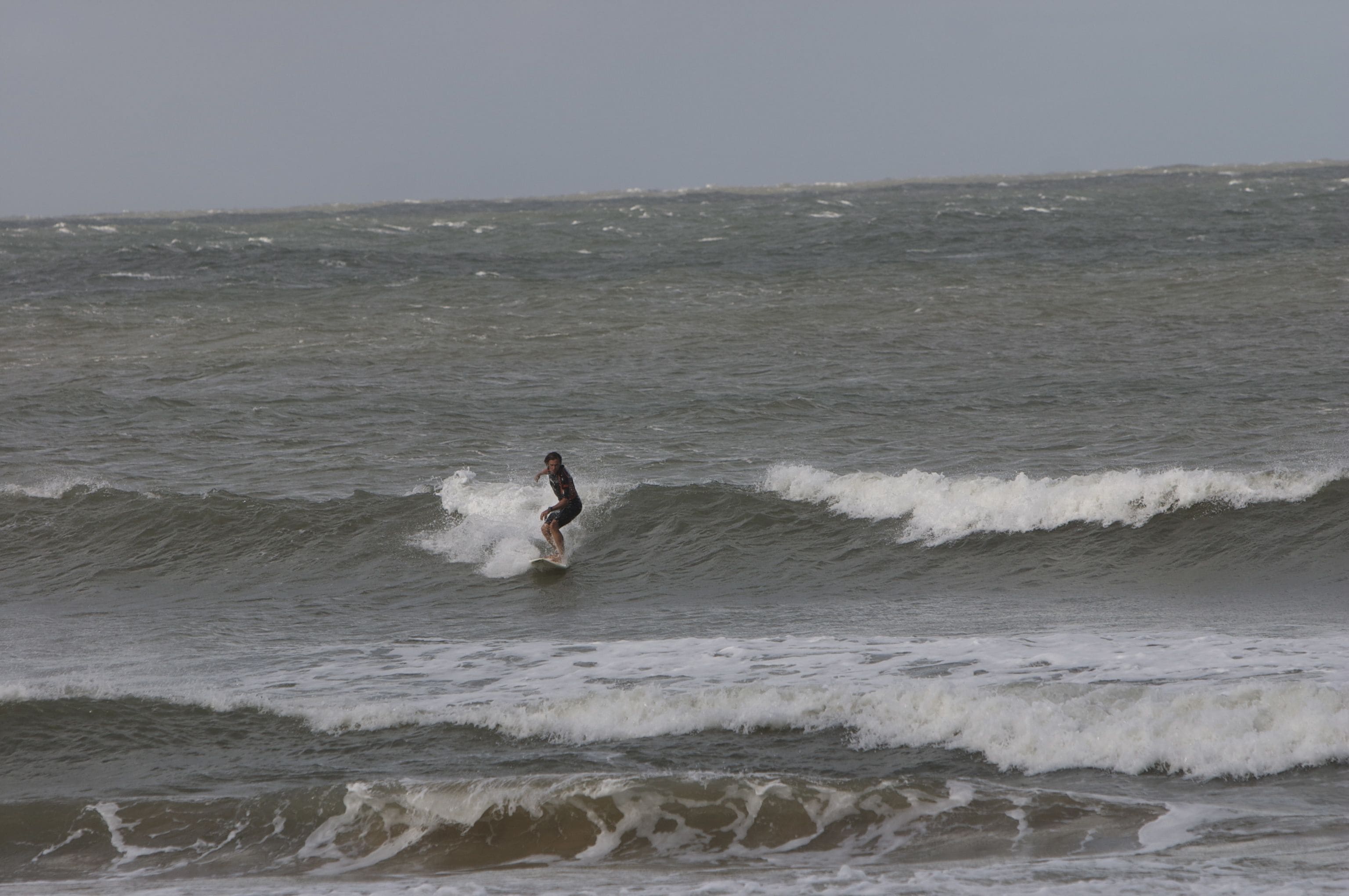 A surfer riding a wave in the ocean.