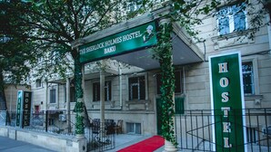 A hostel with a green sign reading "The Sherlock Holmes Hostel Baku".